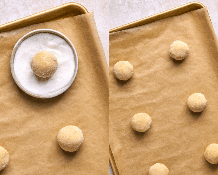 cookie dough balls on cookie sheet with one in a bowl of white granulated sugar