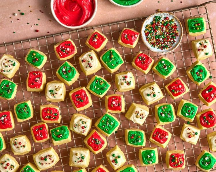 small square cookies topped with red, white, and green frosting and sprinkles