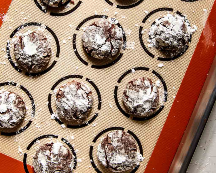 chocolate powdered sugar cookies on a baking sheet.