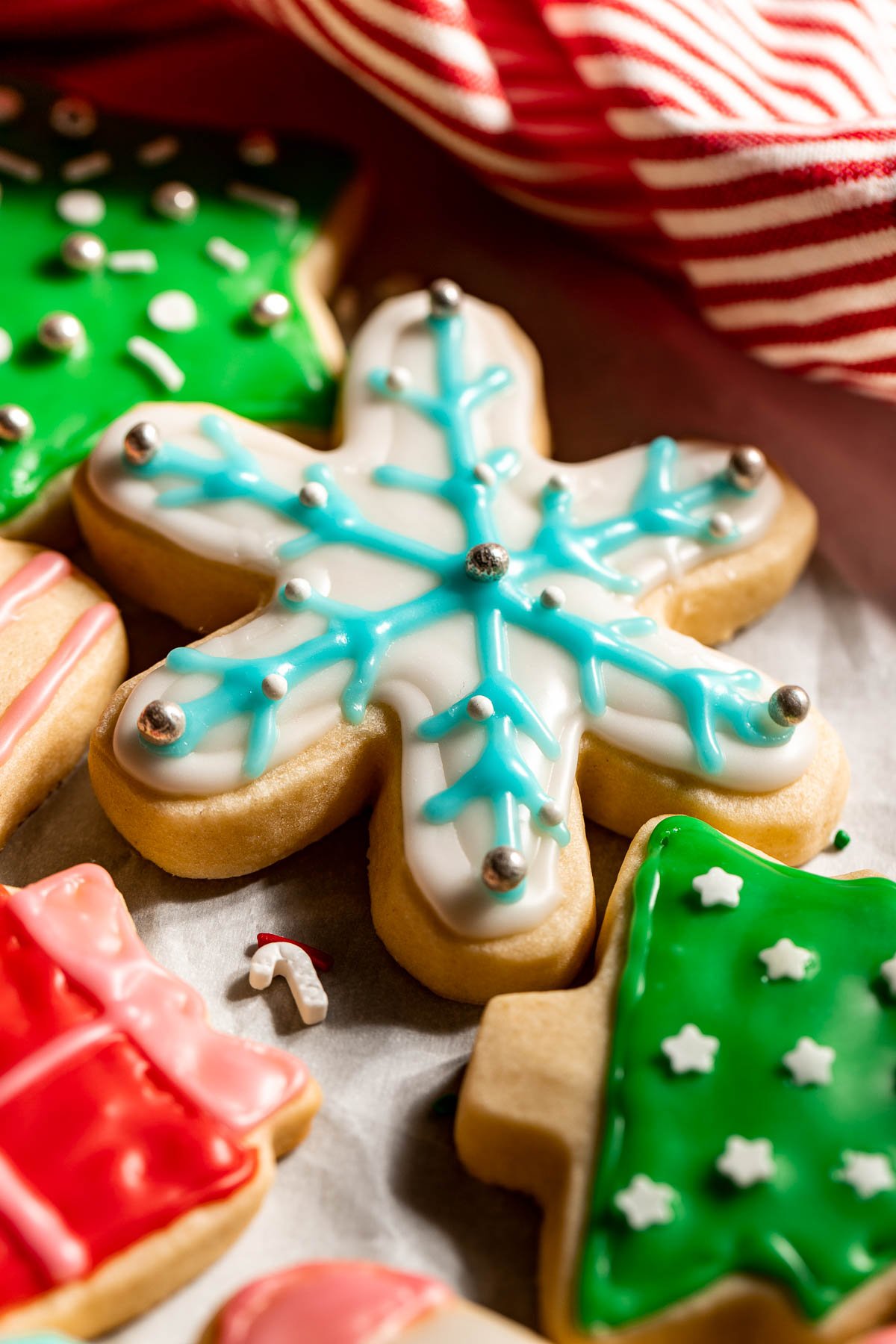 a cutout snowflake sugar cookie decorated with white and light blue frosting. 