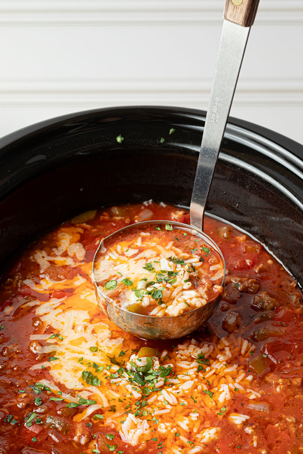 ladle lifting serving of soup out of crockpot.