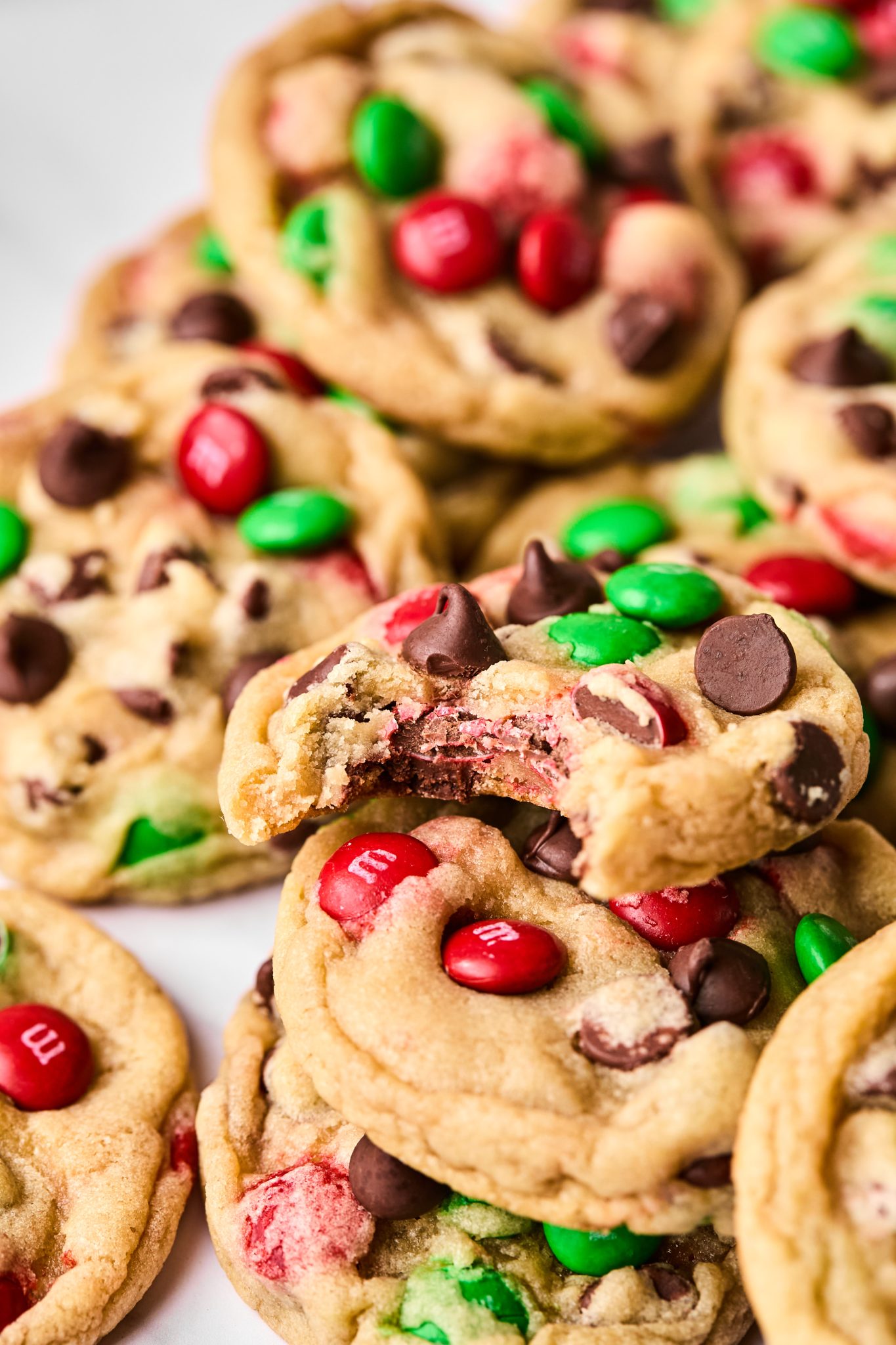 a bite taken out of a cookie made with red and green M&Ms. 