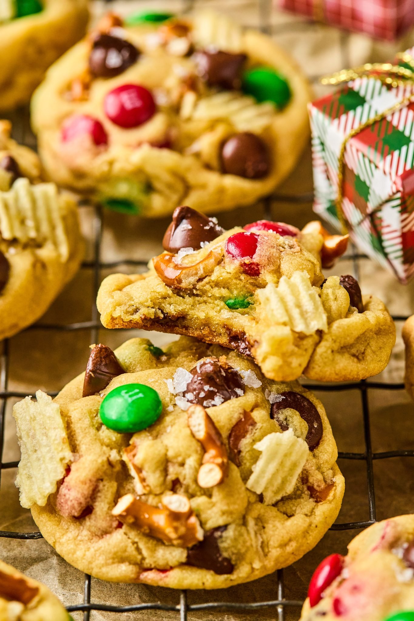 a bite taken out of a cookie filled with wavy cheese, pretzels, and chocolate. 