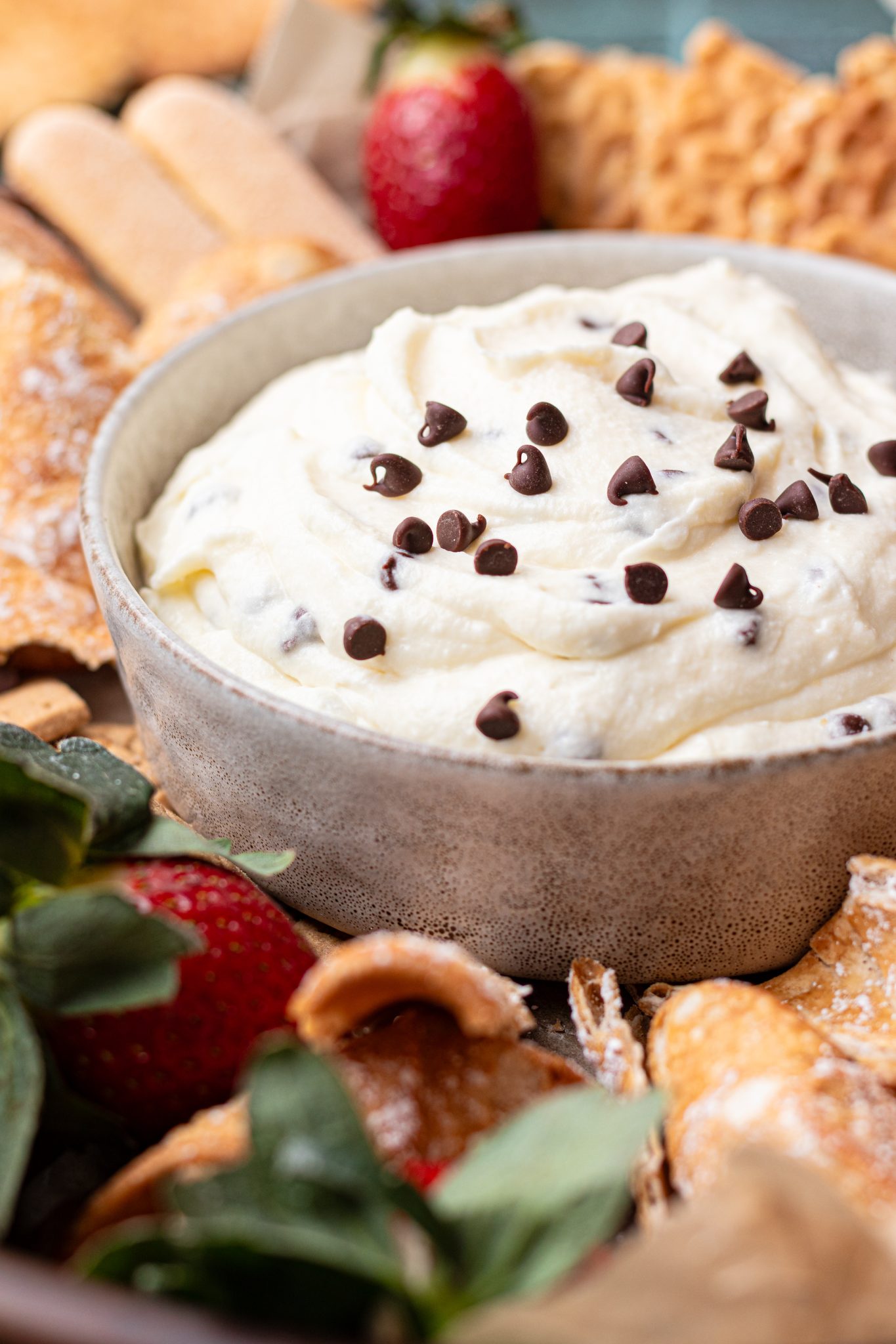 a bowl filled with cannoli dip and sprinkled with mini chocolate chips on top. 