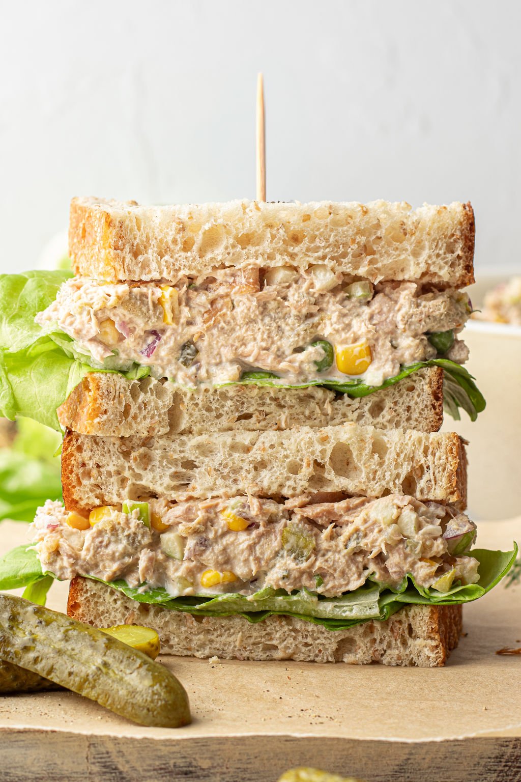 Two halves of a sandwich stacked on another, filled with tuna salad and lettuce.