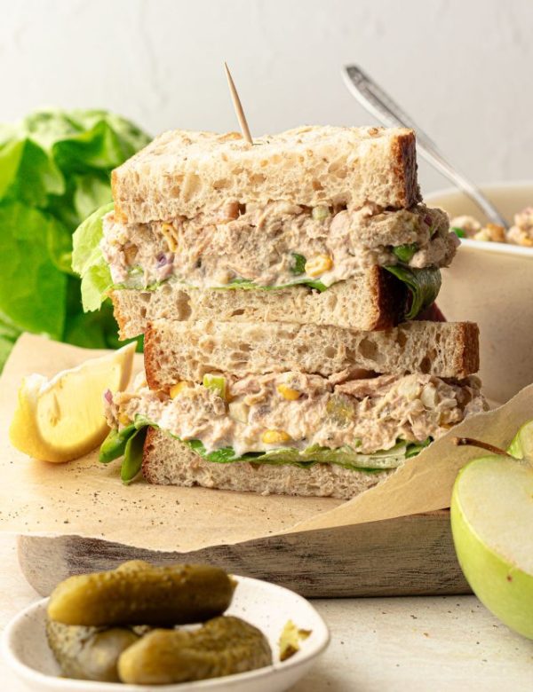 Tuna salad sandwich slices topped on top of one another.