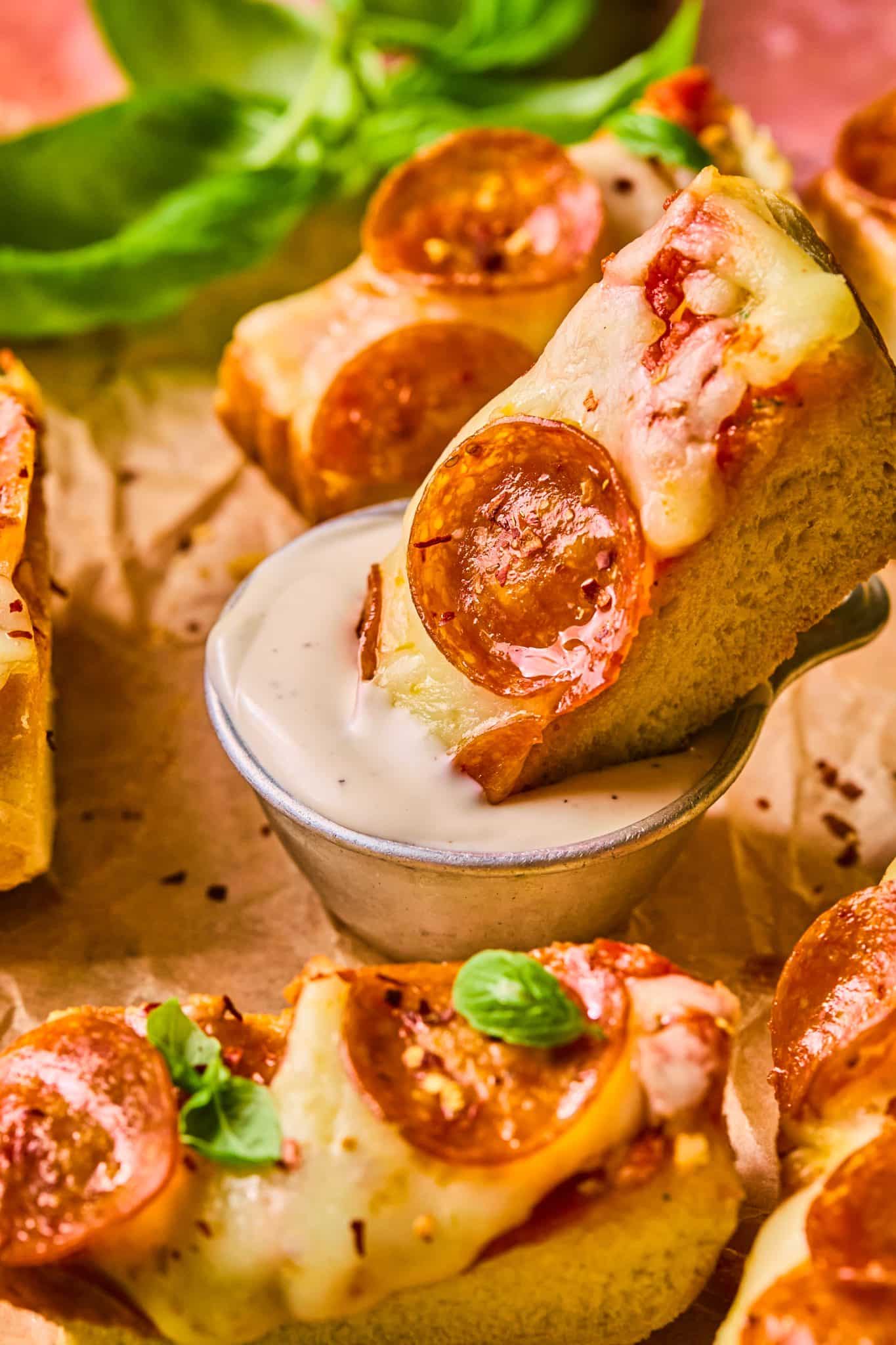 pepperoni pizza being dunked into ranch. 