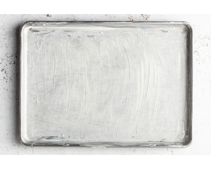 Silver half sheet pan with butter smeared on it.