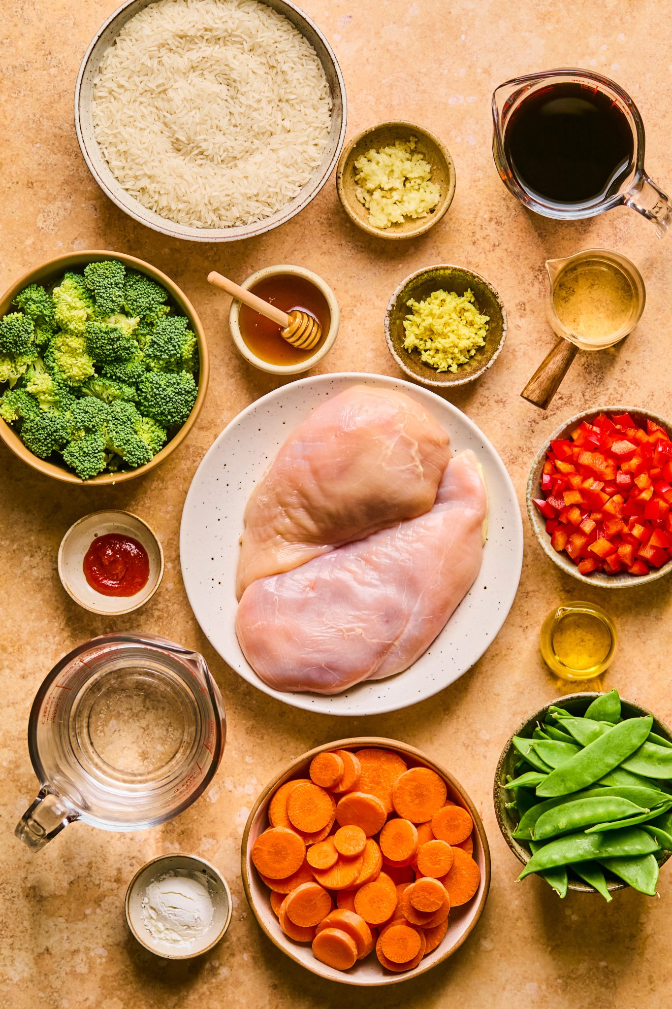 Ingredients in small dishes needed to make rice bowls with chicken and teriyaki. 