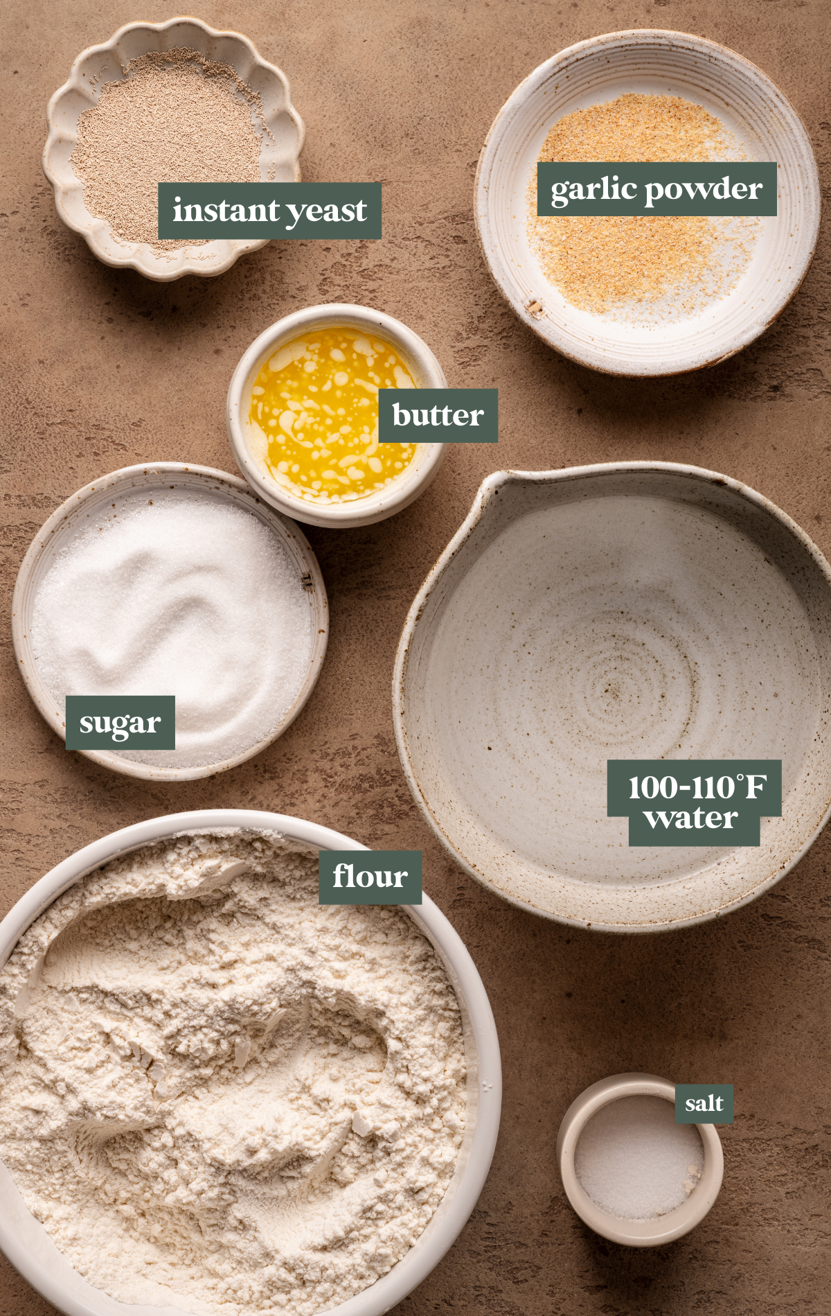 ingredients to make breadsticks in small glass and ceramic dishes. 