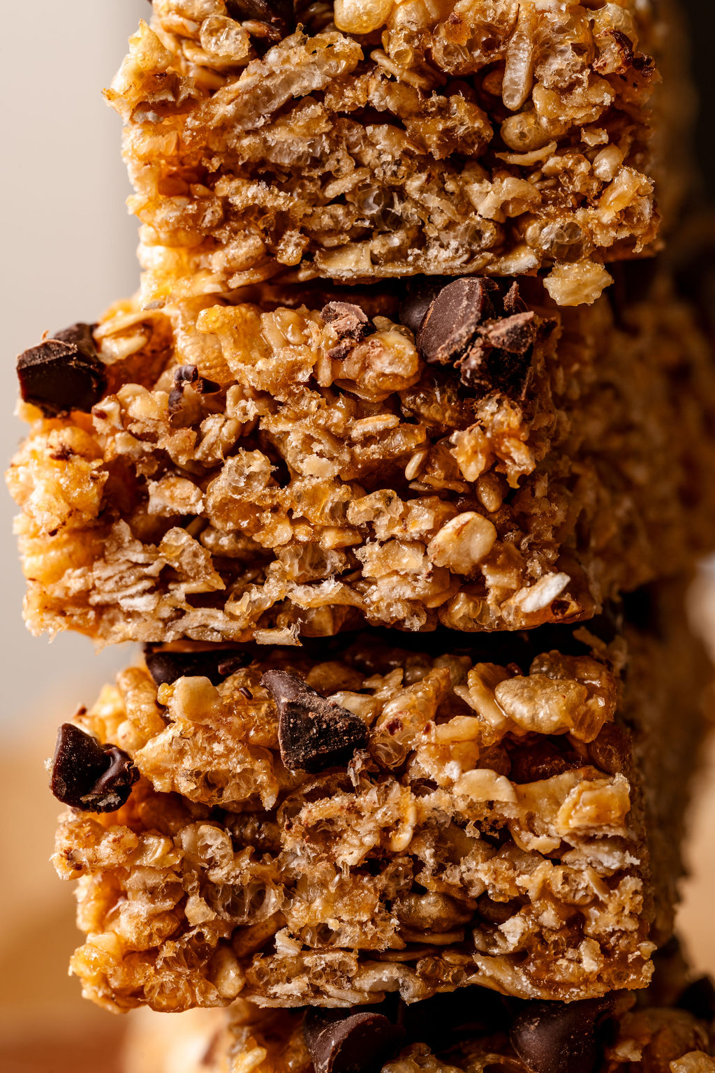 a close up image of stacked granola bars made with mini chocolate chips on top. 