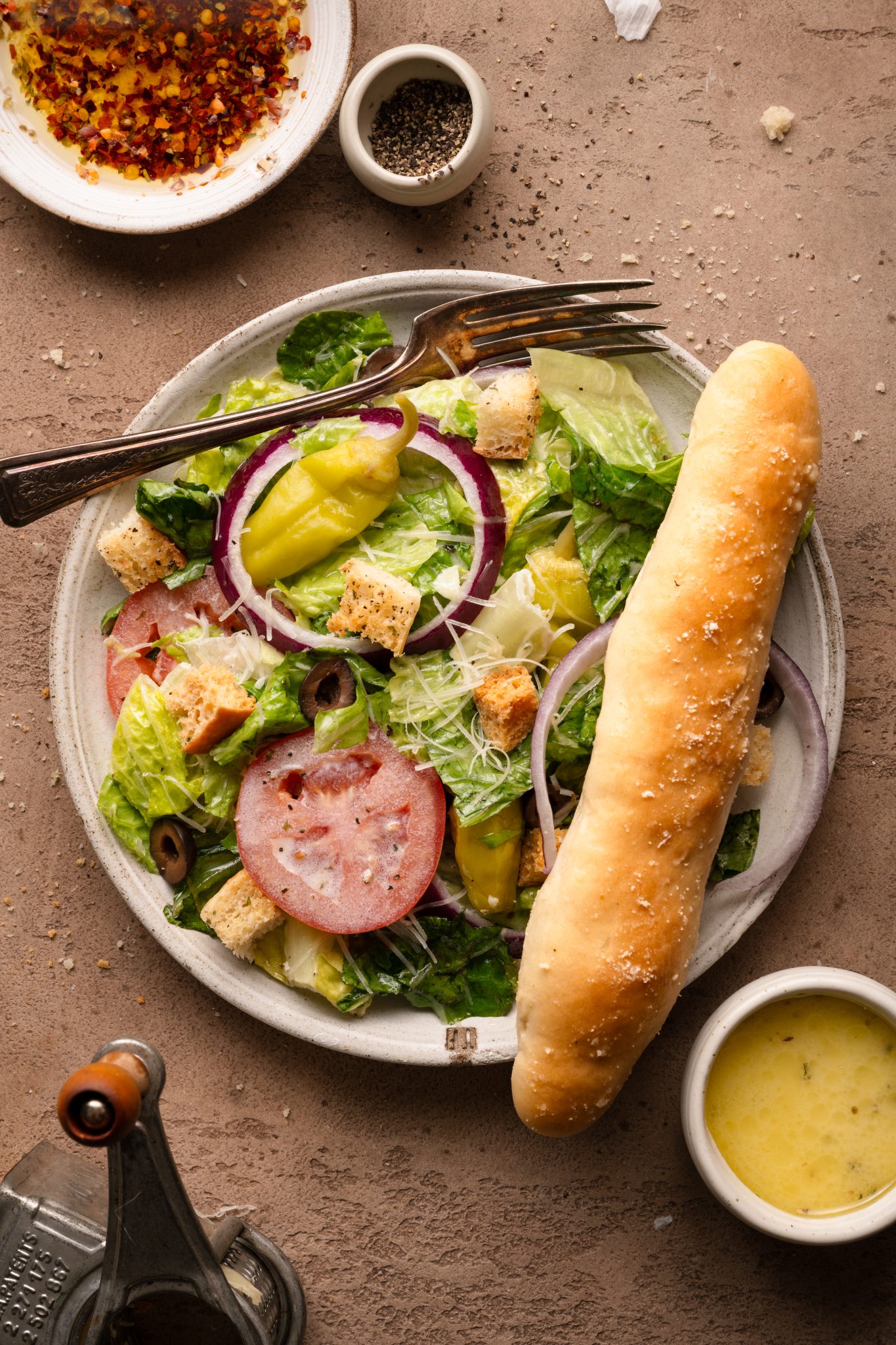 salad and a breadstick on a plate. 