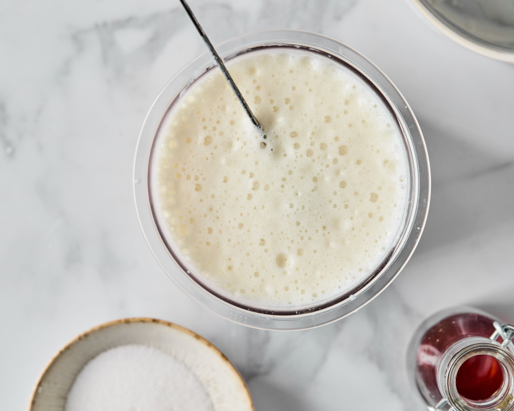 Ingredients whisked together with electric frother for vanilla protein ice cream.