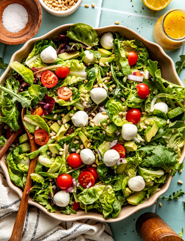 Everyday salad tossed together in large ceramic bowl.