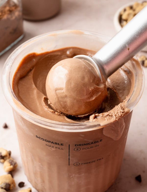 Scooping chocolate ice cream out of ninja creami pint container.