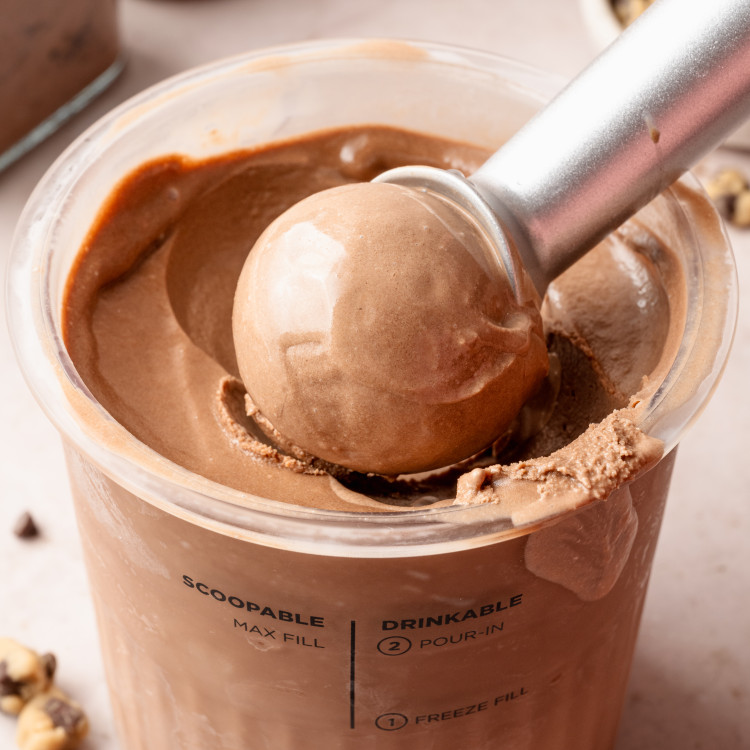 Scooping chocolate ice cream out of ninja creami pint container.