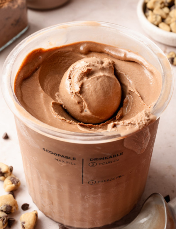 Chocolate ice cream scooped up in pint container.