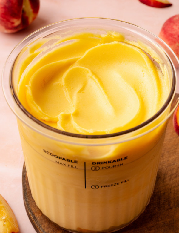 Ninja creami peach sorbet in pint container smoothed out on top.