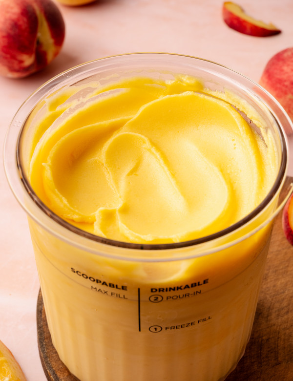 Ninja creami peach sorbet in pint container smoothed out on top.