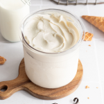 Ninja creami vanilla frozen yogurt in pint container on top of wooden board.
