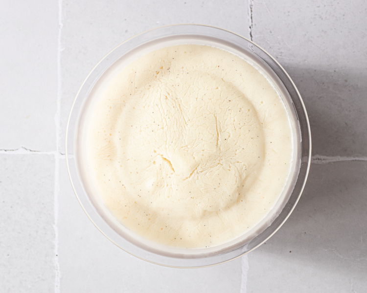 Ninja creami vanilla frozen yogurt frozen in ninja creami pint container.
