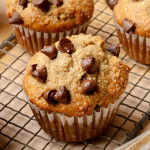 Upclose shot of 3 banana chocolate chip muffins cooling on wire rack.