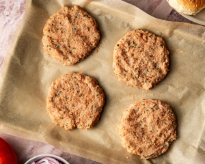 Forming four patties with chicken mixture and placing on sheet pan lined with parchment paper to chill for 15-20 minutes.