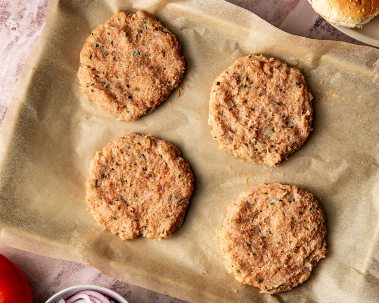 Forming four patties with chicken mixture and placing on sheet pan lined with parchment paper to chill for 15-20 minutes.
