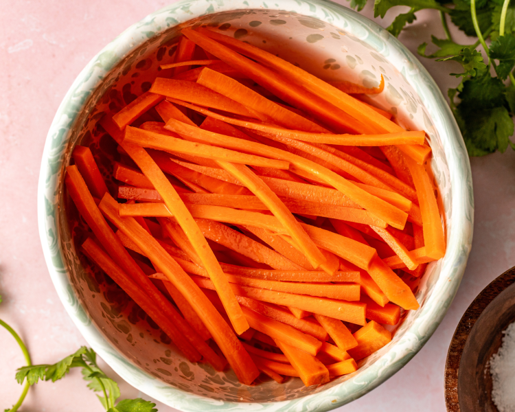 Raw carrots in bowl ready to add pickling ingredients.
