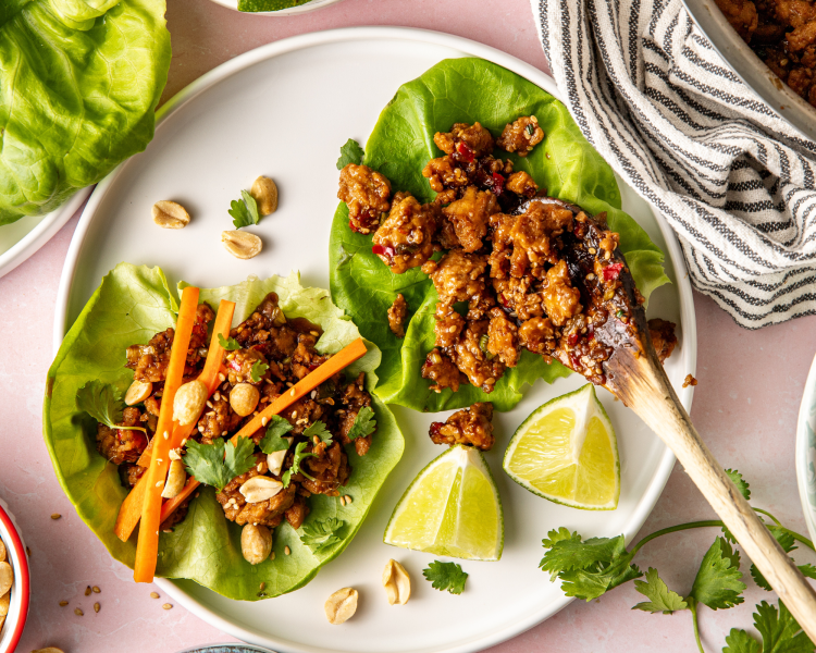 Add chicken mixture to lettuce leaf on white plate.