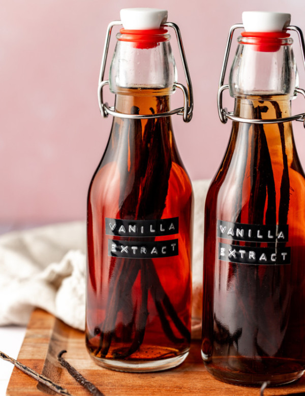 Two bottles of homemade vanilla extract on cutting board.
