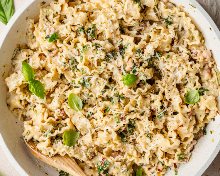 Zucchini lemon pasta in serving bowl with fresh basil.