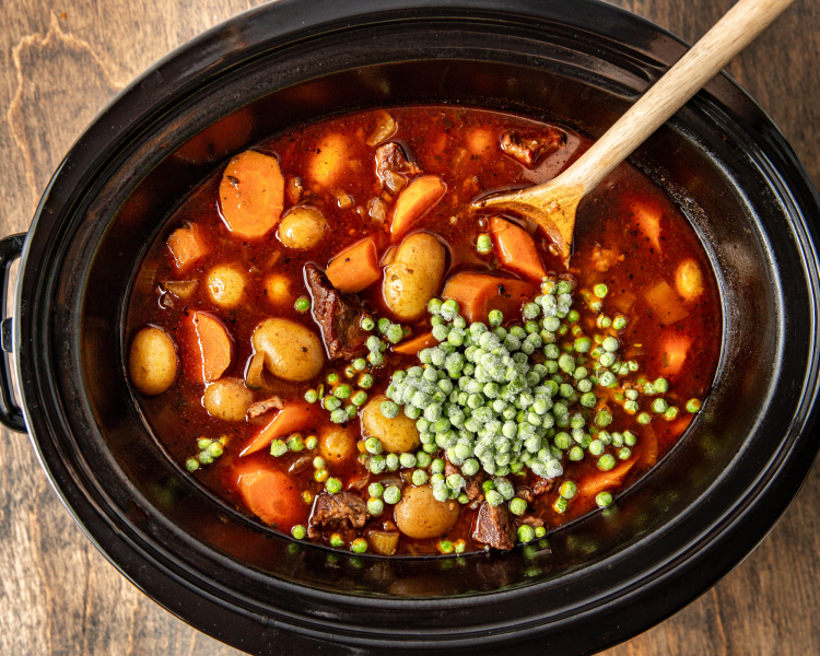 Adding the frozen peas the last 15 minutes of cooking the beef stew in the slow cooker.