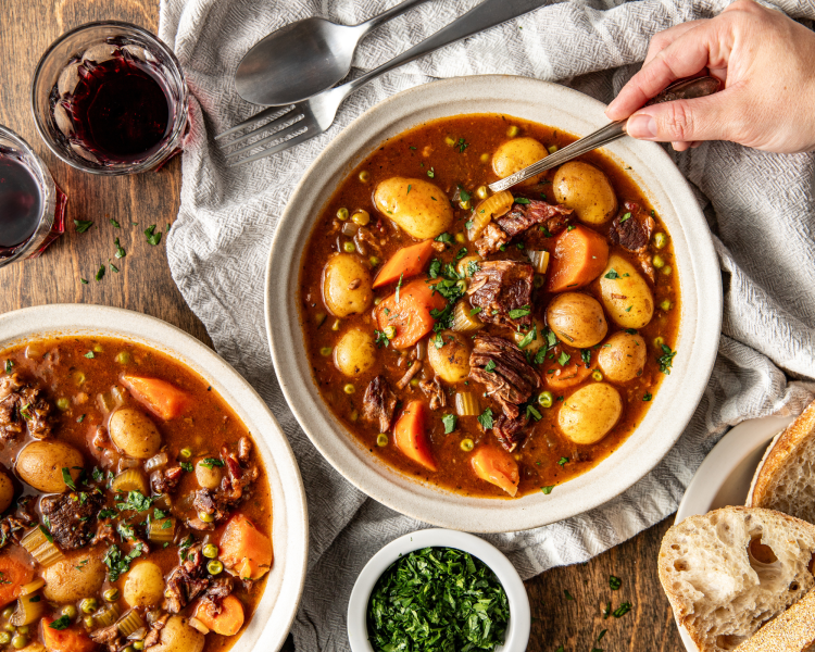 Beef stew in bowls with spoon ready to serve.