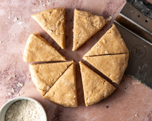 Cinnamon scone dough cut into 8 triangles.