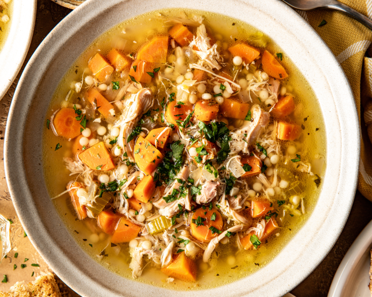 Lemon chicken soup in white bowl.