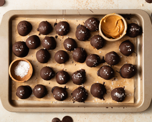 Tray of chocolate covered peanut butter snack bites after chilling in the freezer for 30 minutes to let chocolate set.