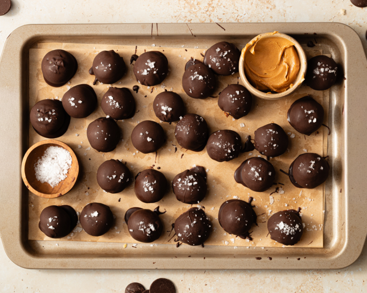 Tray of chocolate covered peanut butter snack bites after chilling in the freezer for 30 minutes to let chocolate set.