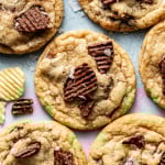 Baked chocolate potato chip cookies on table garnished with flaky sea salt.