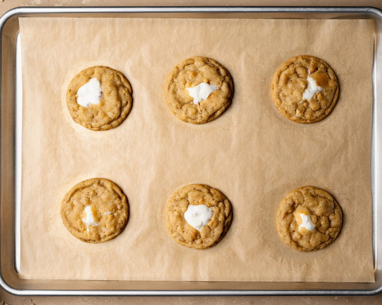 Six rice krispie cookies baked on baking sheet lined with parchment paper.