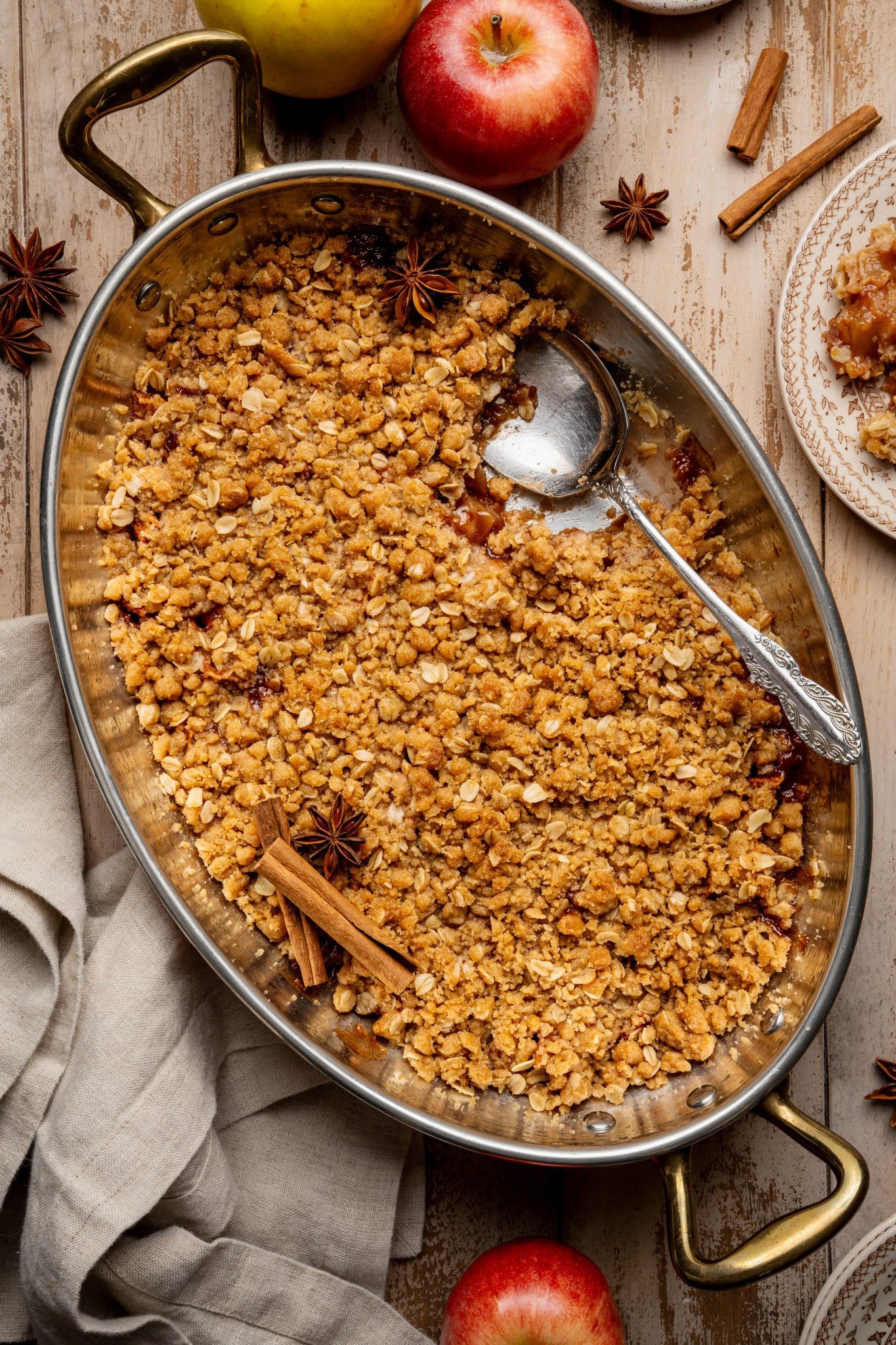 Apple crisp in baking dish with spoon.