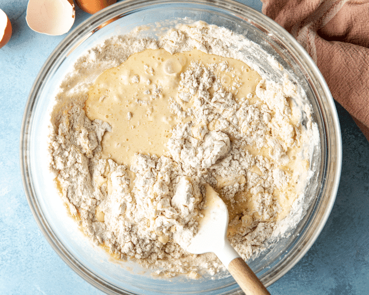 Mixing the wet ingredients into the dry ingredients for buttermilk waffles.