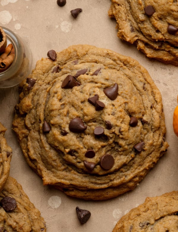 Bakery-style pumpkin chocolate chip cookie on parchment paper.