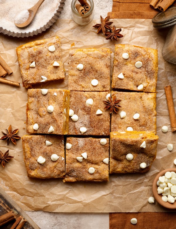 Pumpkin snickerdoodle blondies cut into 9 squares and garnished with cinnamon cloves.