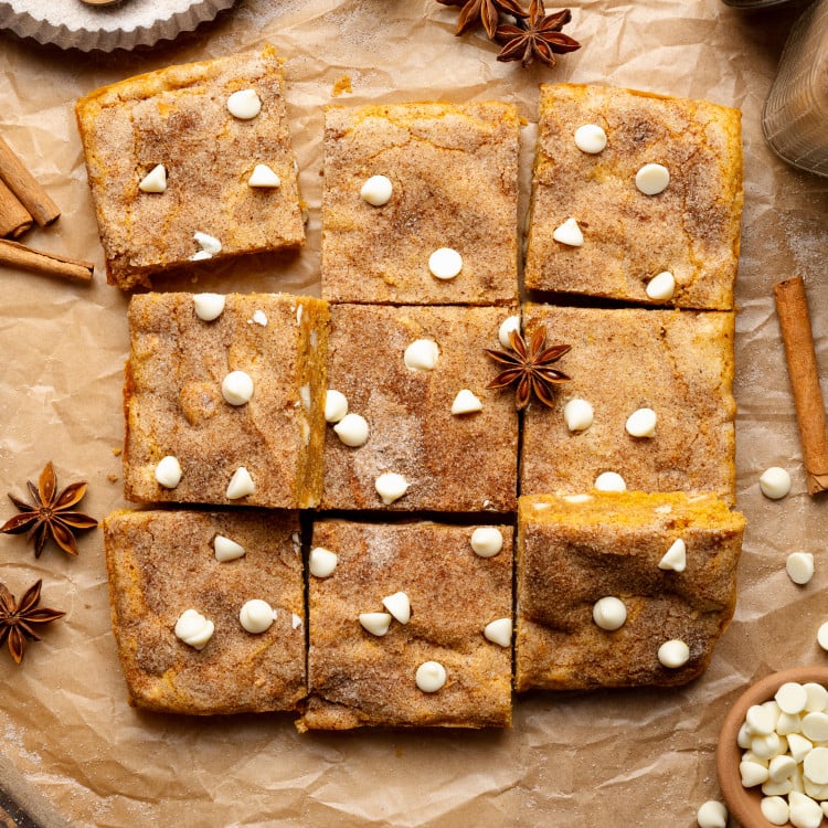 Pumpkin snickerdoodle blondies cut into 9 squares and garnished with cinnamon cloves.