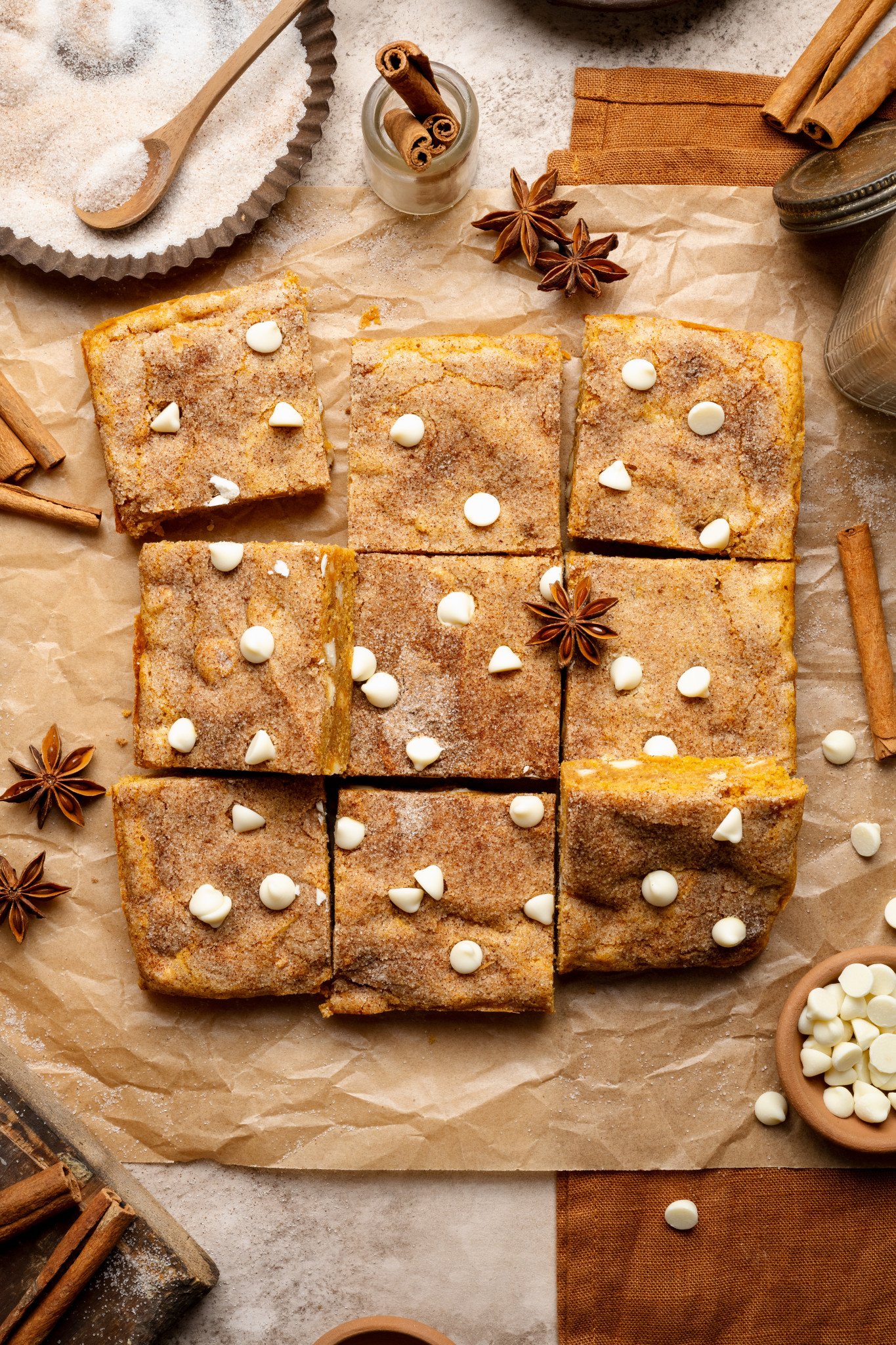 Pumpkin snickerdoodle blondies cut into 9 squares and garnished with cinnamon cloves.