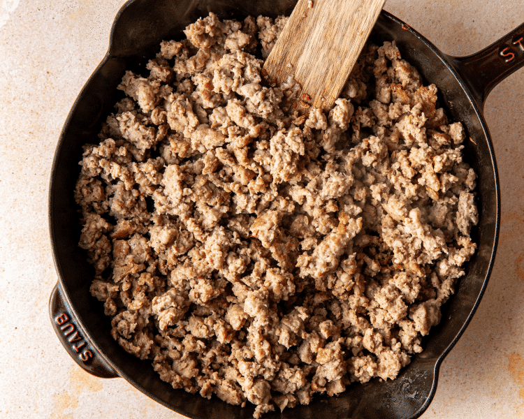 Italian sausage cooked in skillet before adding to slow cooker.