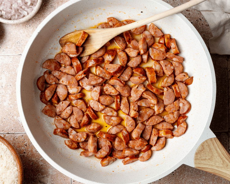 Adding chorizo to skillet and cooking for a few minutes to get crispy.