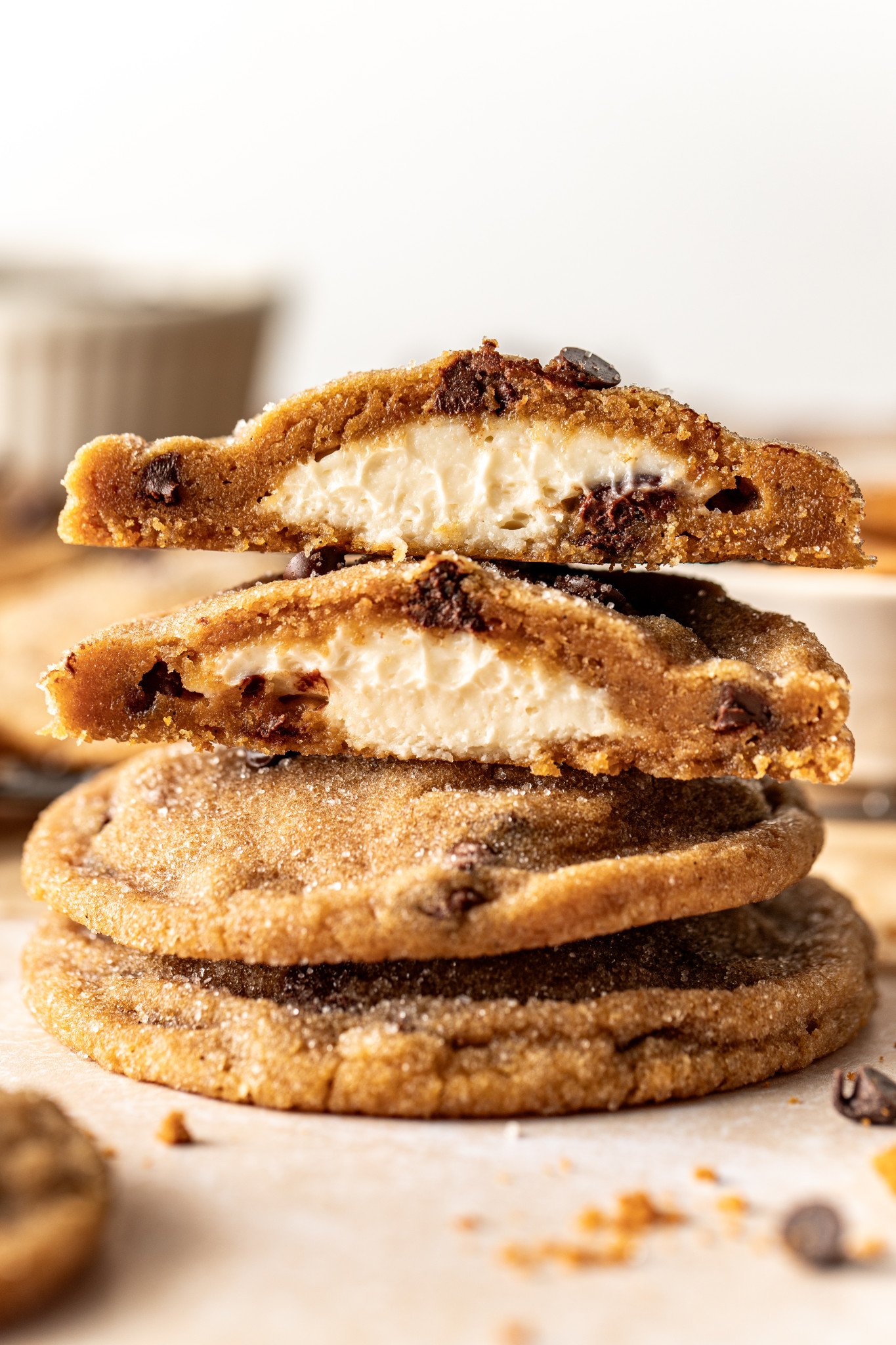 Biscoff cheesecake cookies stacked on top of each other with top cookie broken in half to show cheesecake center.