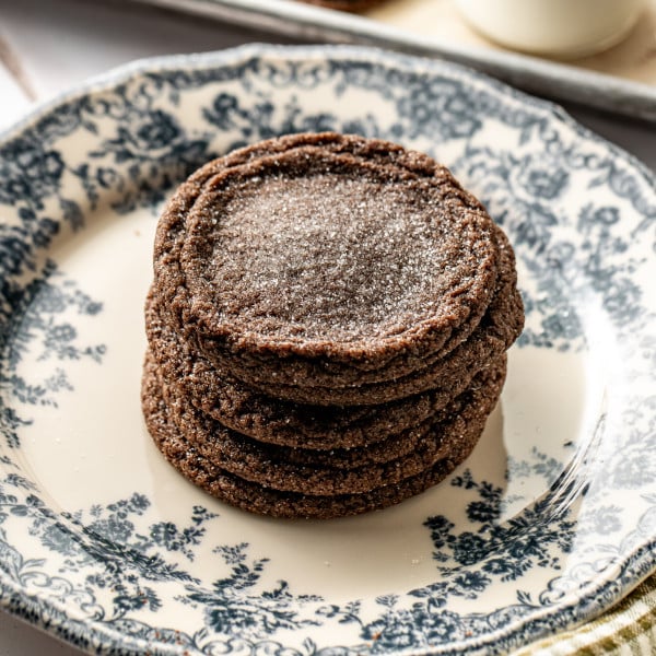 Chewy chocolate chip cookies stacked on top of each other on blue floral plate.